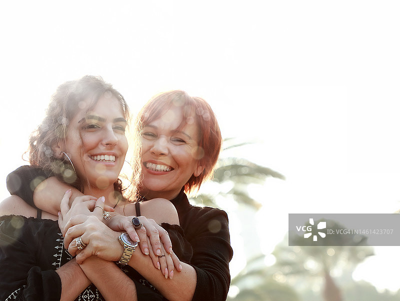 快乐的单身母亲和年轻的成年女儿在公园里的户外写真图片素材