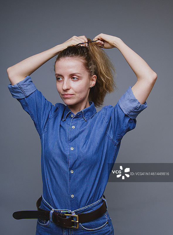 穿着牛仔服装整理头发的女人图片素材