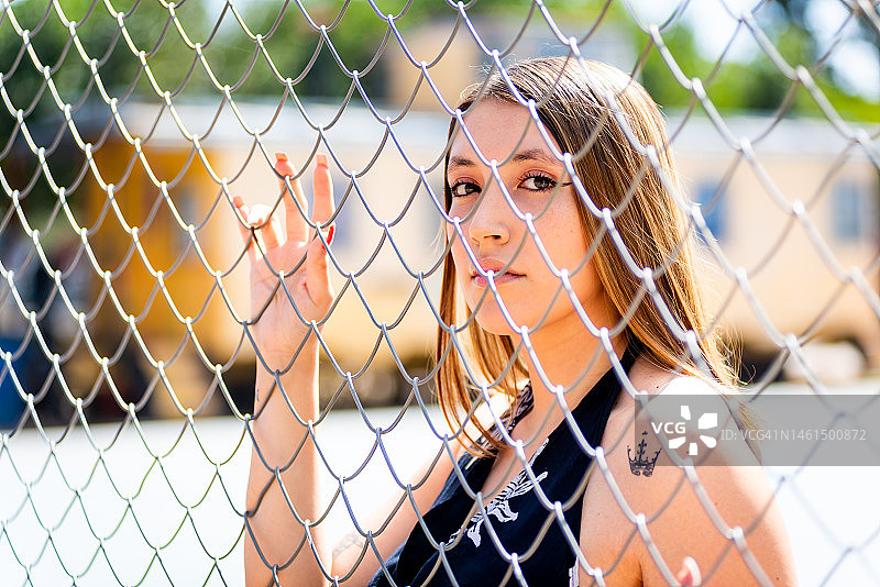 年轻女子在铁丝网后面的肖像图片素材