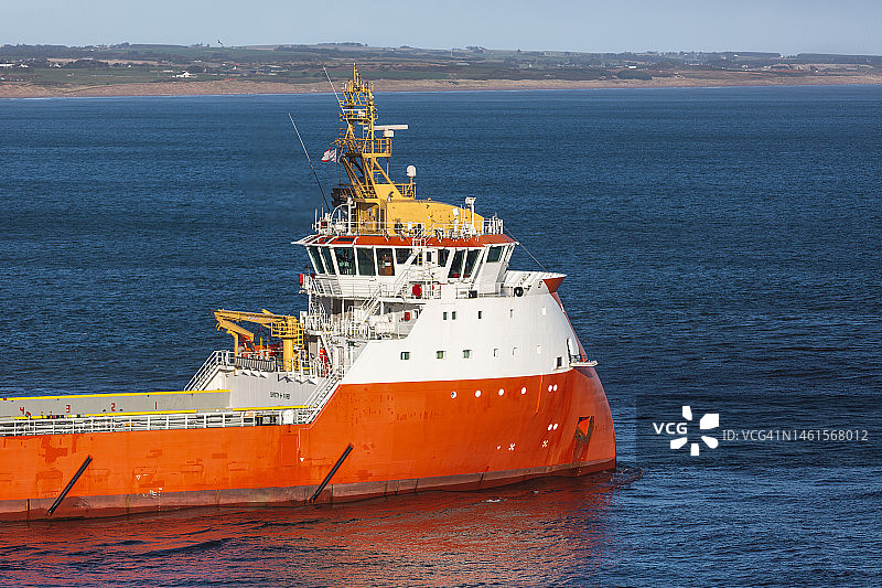 平静海水中石油钻井平台的补给船图片素材