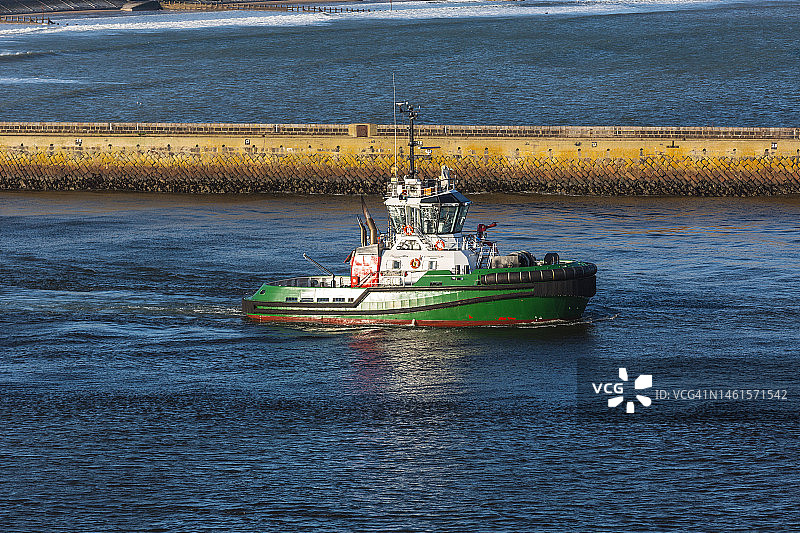 离开英国阿伯丁港的小型拖船图片素材