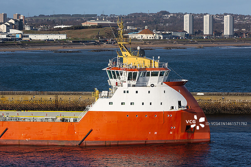 离开苏格兰阿伯丁港口的石油钻井平台支持船图片素材