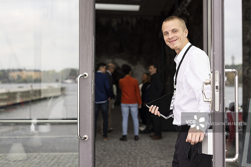 会议中心门口微笑着的年轻商务人士图片素材