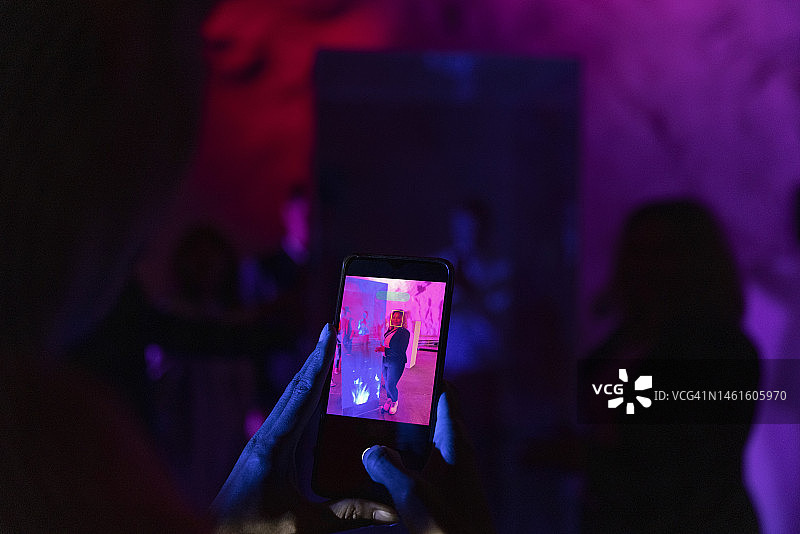 女商人通过智能手机为她在会议中心的同事拍照的裁剪图像图片素材