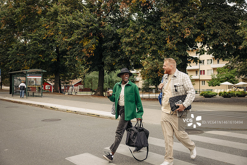 快乐的男人们在城市道路上交谈图片素材