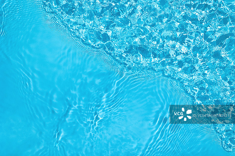 阳光下带有波纹，飞溅和波浪的鲜艳粉彩蓝色透明清水表面纹理图片素材