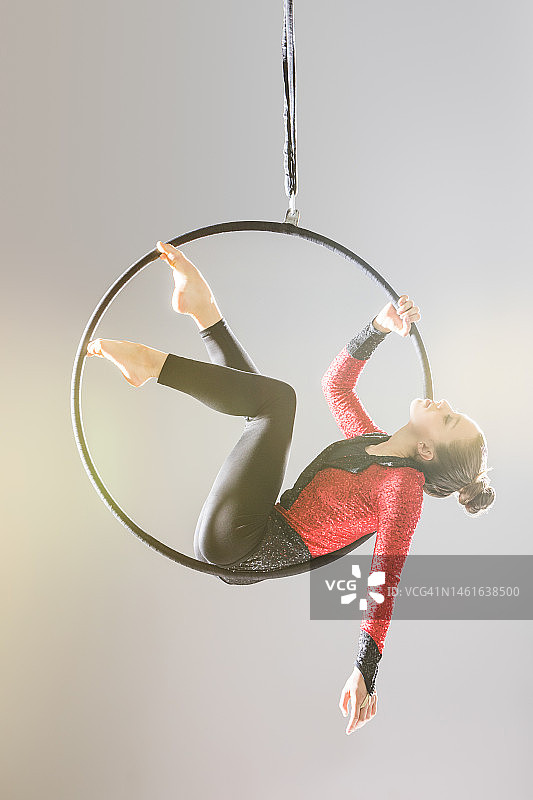 年轻的杂技演员在空中吊环上表演图片素材