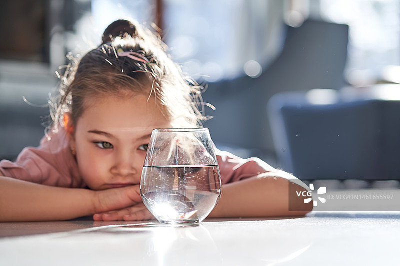 身穿粉色衣服躺在大理石地板上看水的女孩图片素材