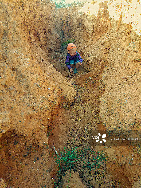 在小峡谷里探索地面的幼儿男孩图片素材