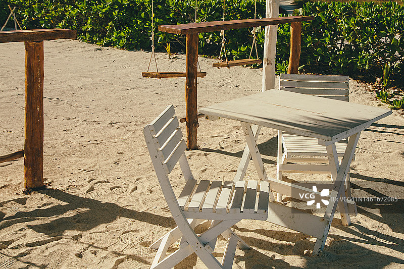 沙滩上的白色木制桌椅图片素材