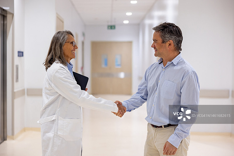 医生在医院走廊问候男士图片素材