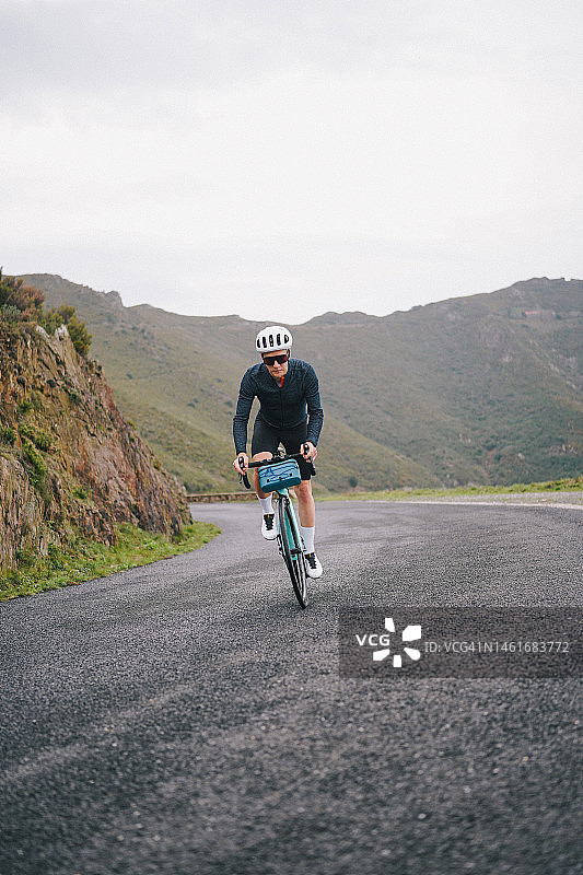 骑行者在海上蜿蜒的道路上骑行图片素材