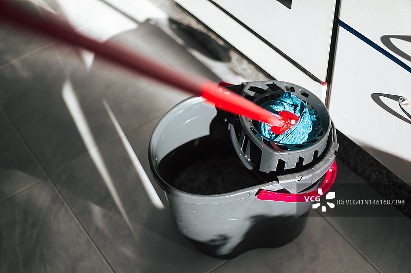 厨房里的拖把和清洁桶特写，有阴影图片素材