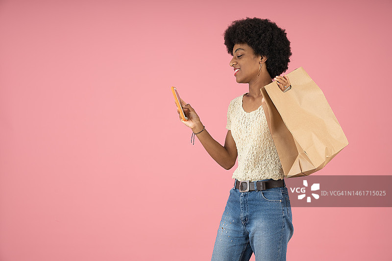 年轻黑人女性拿着外卖食品袋，正在查看手机图片素材