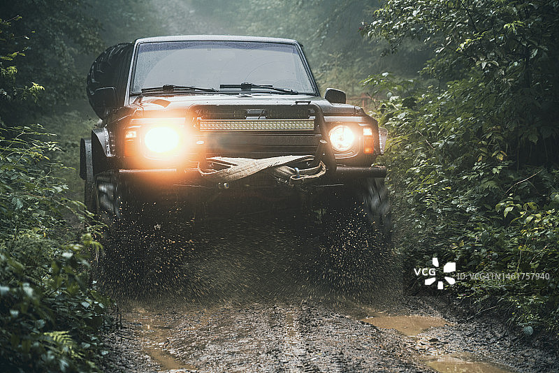 定制越野车在森林湿路上行驶图片素材