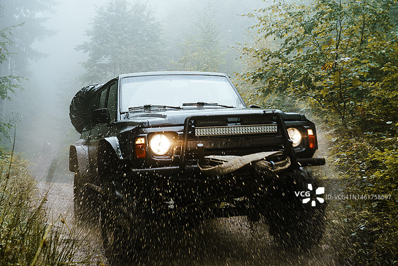 定制越野车在森林湿路上行驶图片素材
