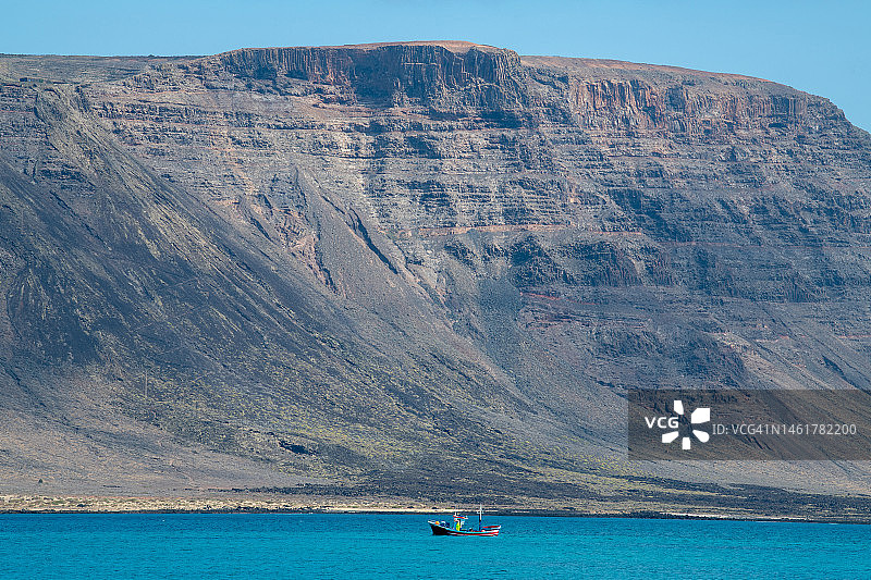 兰萨罗特岛法马拉悬崖附近航行的渔船图片素材
