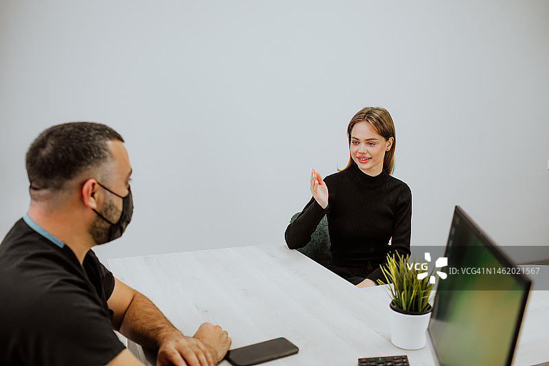 客户在带白色桌子的房间里洽谈图片素材