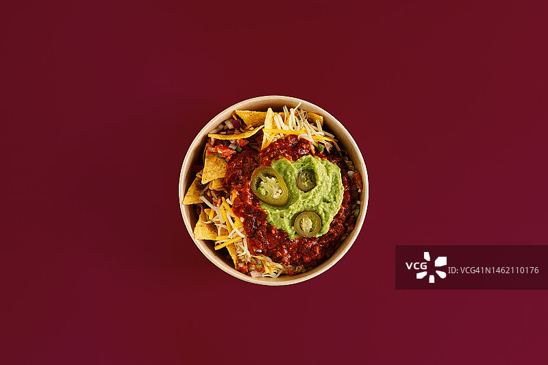 纯栗色背景下的一盘玉米片，传统墨西哥食物俯视图图片素材