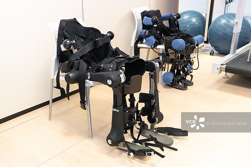 现代化医院的机械外骨骼理疗：先进的机器人外骨骼等待患者，理疗康复科学家、工程师和医生图片素材