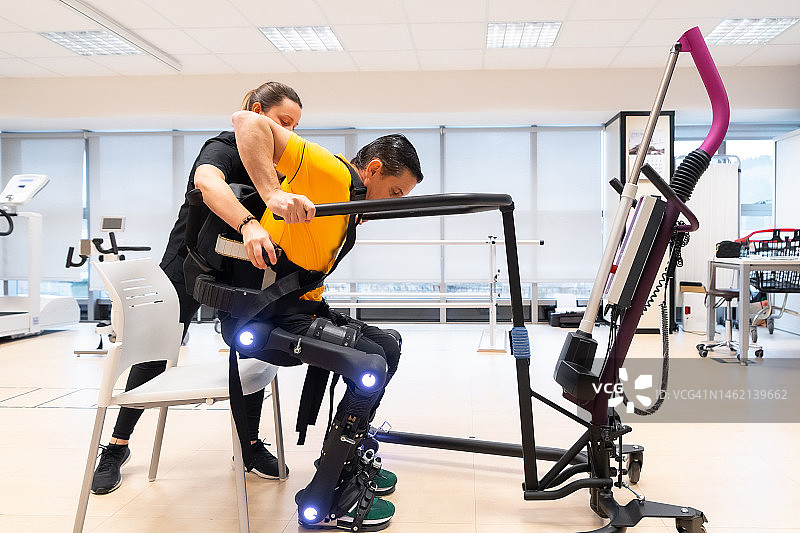 机械外骨骼：理疗师帮助残疾人使用机器人骨骼图片素材