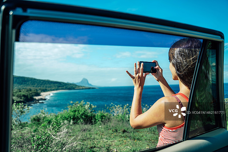 在努沙登加拉热带海滩用科技设备拍照的女子图片素材