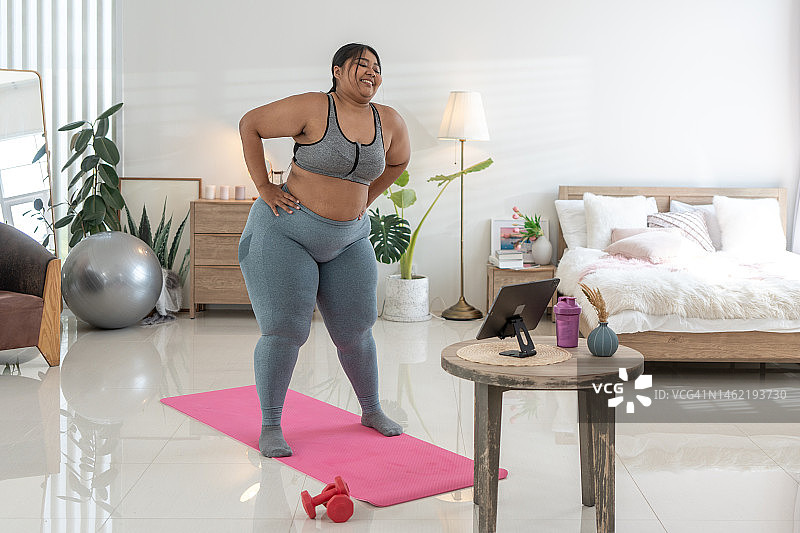 超重妇女在家用哑铃锻炼图片素材