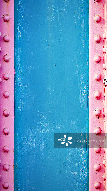 伦敦的铆接、涂漆和风化的蓝粉色金属板图片素材