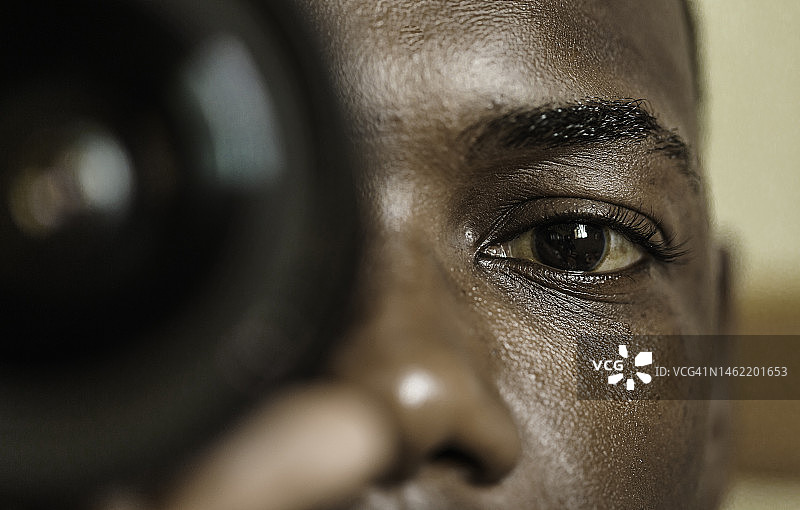 黑人摄影师通过镜头看相机图片素材