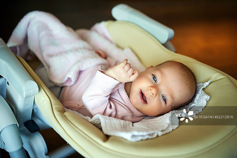 快乐的女婴在摇椅上放松图片素材