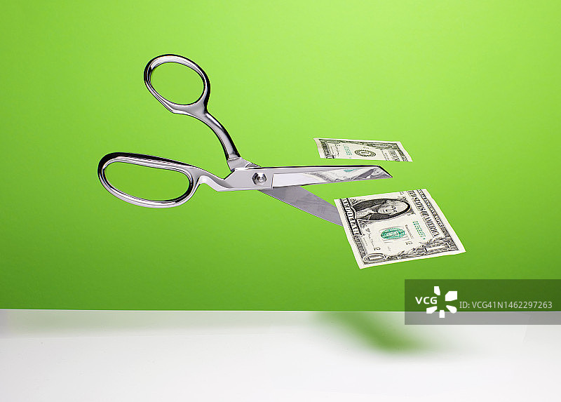 削减预算——剪刀和美元图片素材