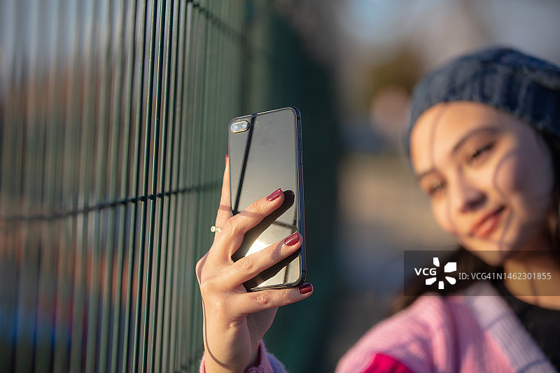 夕阳下自拍的年轻女孩图片素材
