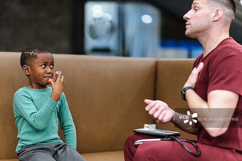 医生教患有哮喘的儿童如何使用吸入器图片素材