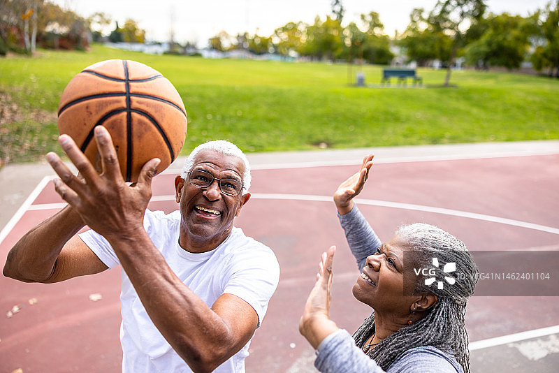 年长的黑人男子在篮球场上投篮图片素材