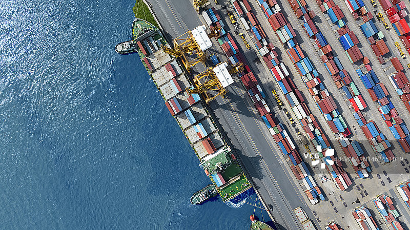 在泰国亚洲港口，起重机正在港口装载集装箱的航拍顶视图图片素材