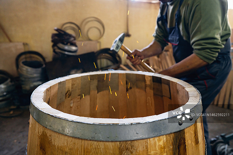 制桶匠烧烤橡木桶，使木板弯曲成桶形图片素材