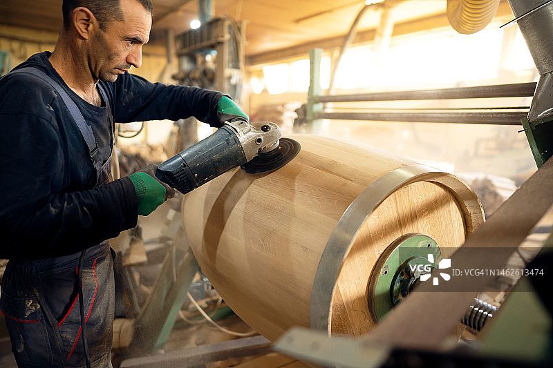 制桶工人用砂光机抛光橡木桶图片素材