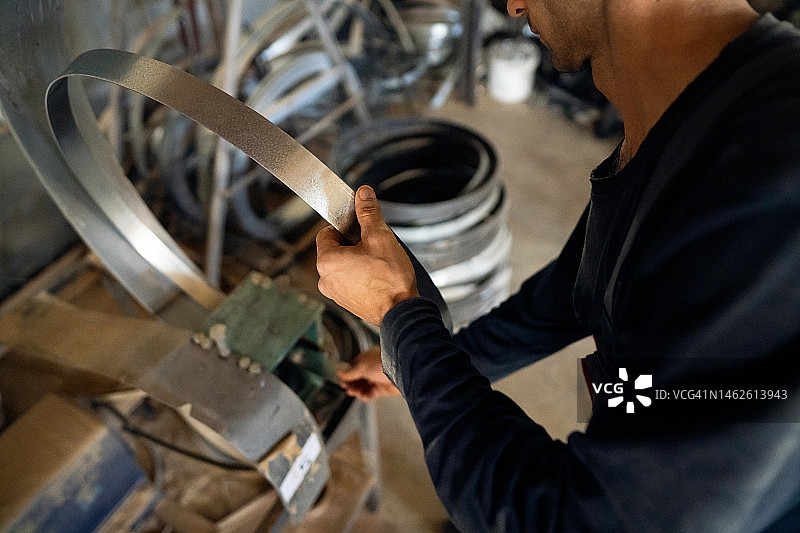 男制桶匠用机器弯曲桶箍图片素材