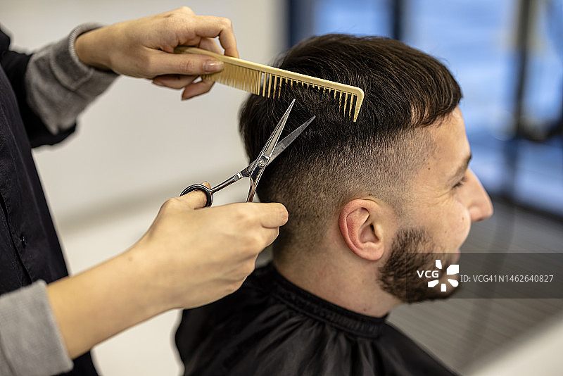 年轻时尚男人在理发店理发图片素材