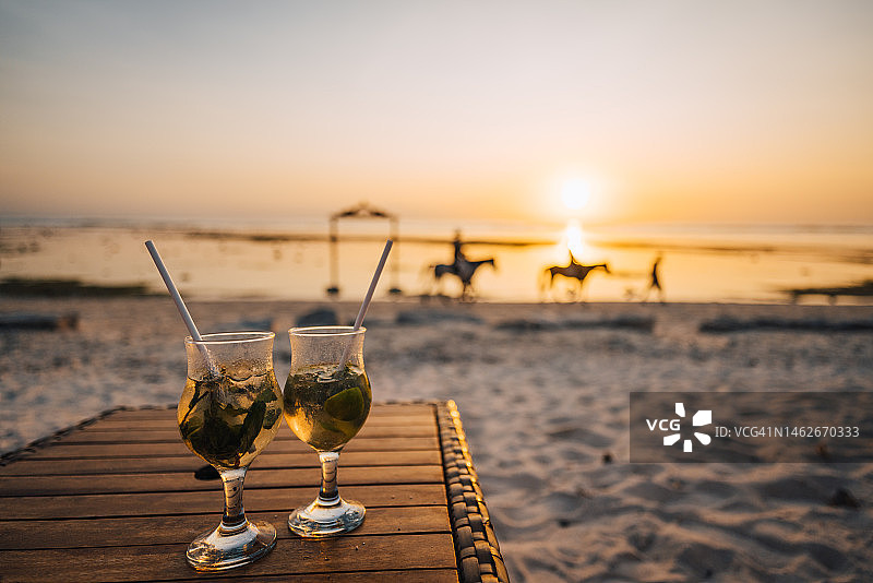 吉利特拉旺岸海滩日落下的鸡尾酒图片素材