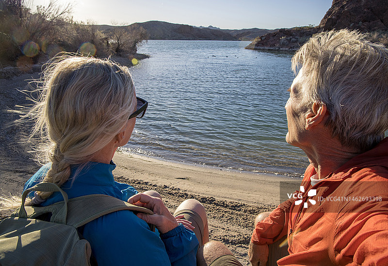 在空旷湖岸边休息的年长徒步夫妇图片素材