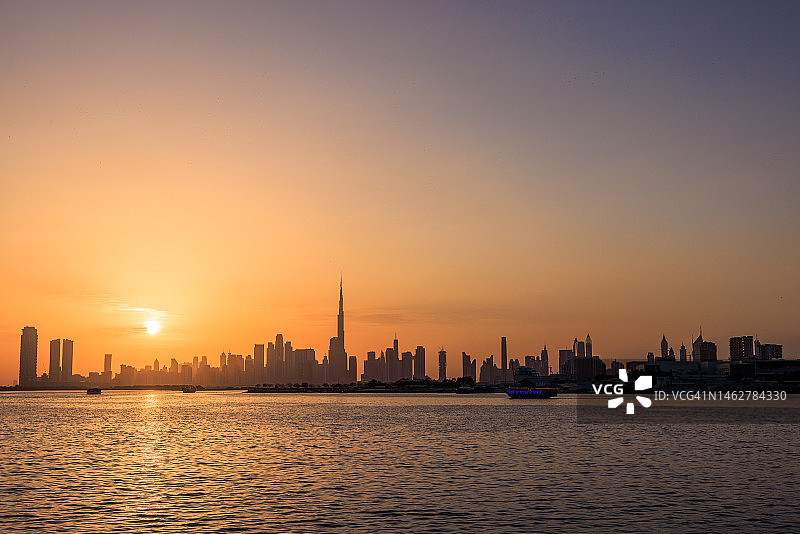 阴天时从湖边看到的迪拜城市天际线图片素材