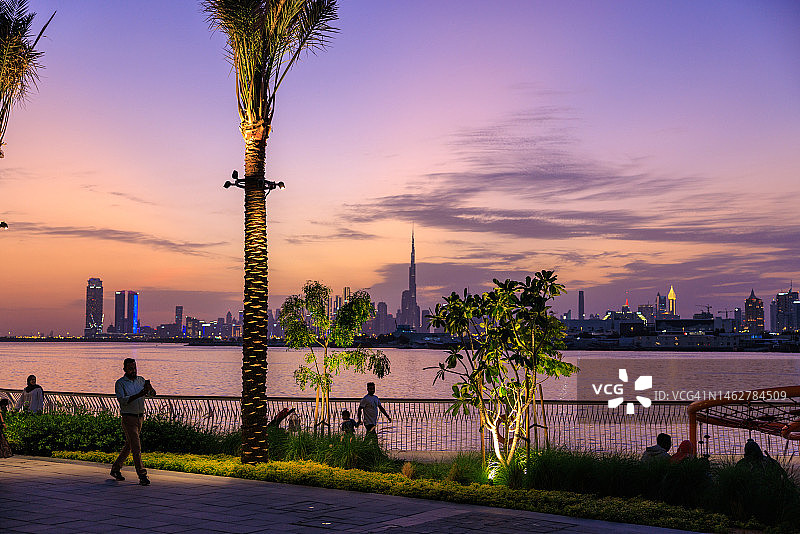 日落时分的迪拜河港与未来城市天际线图片素材