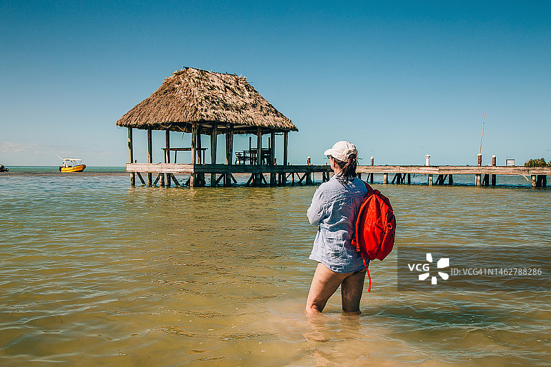 在海滩上背着背包的中年妇女图片素材