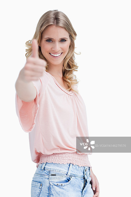 金发女子竖起大拇指对着镜头微笑图片素材