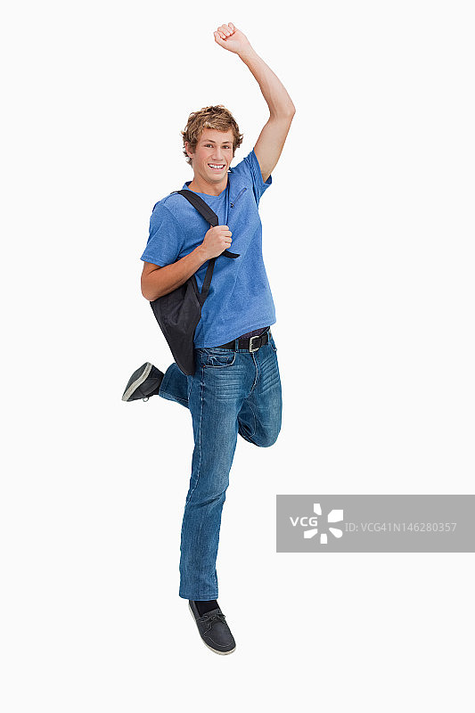 背着背包跳跃的年轻金发男子图片素材