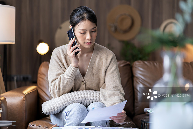 破产：亚洲妇女在家与银行通话，因财务预算失败而沮丧图片素材