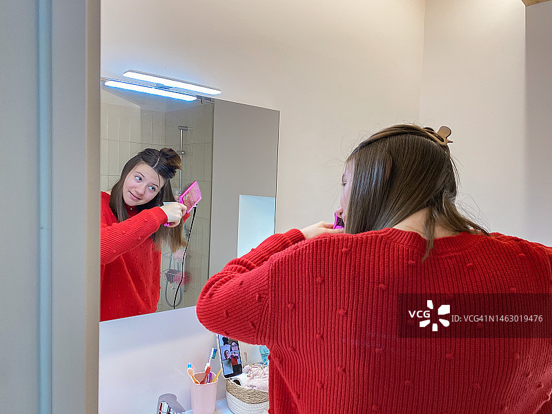 美丽的少女正在熨头发图片素材