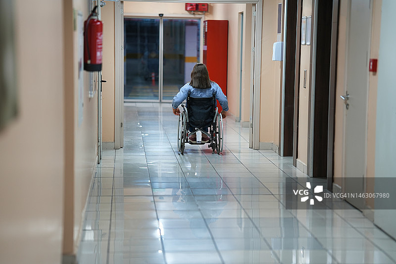 坐在轮椅上的建筑内女人图片素材