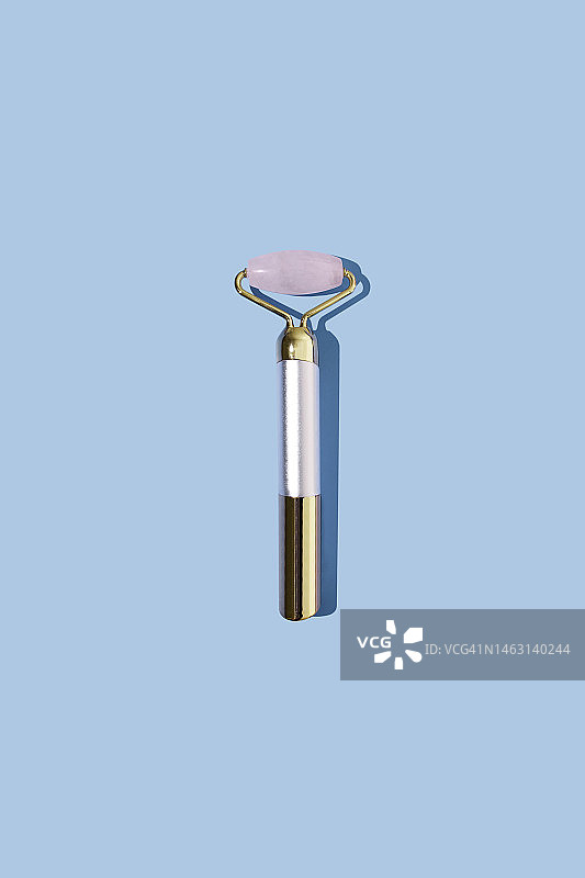 蓝色背景上的粉色石英刮痧板图片素材